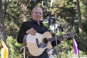 Phil Alvin onstage with an acoustic guitar