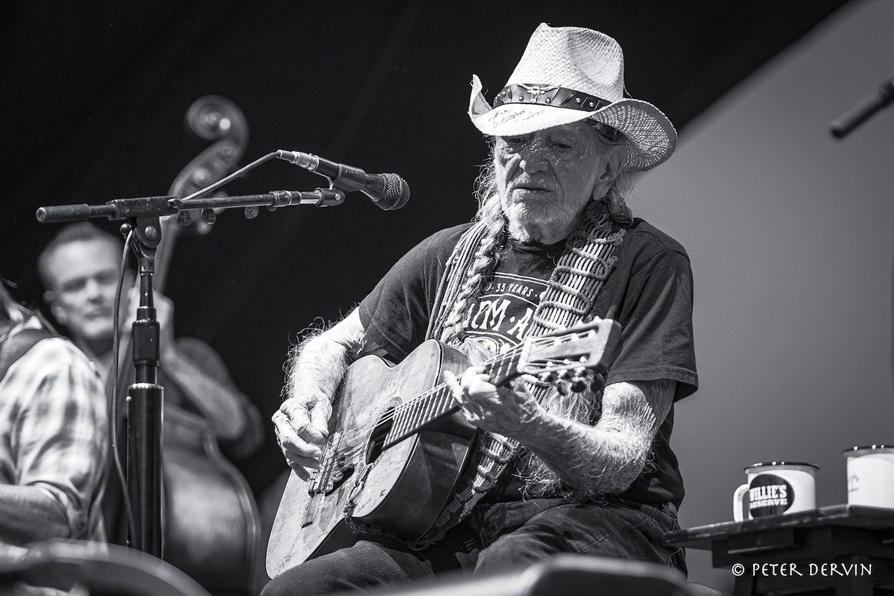 A black and white photo of Willie Nelson on stage