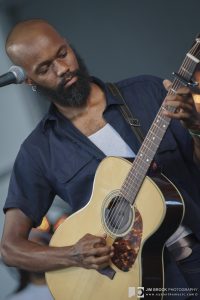 Buffalo Nichols plays an acoustic guitar at the Black Opry Revue set at the 2022 Newport Folk Festival. 