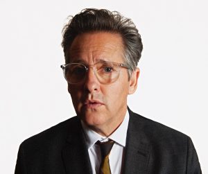 Portrait of a man in a suit with glasses and a serious expression