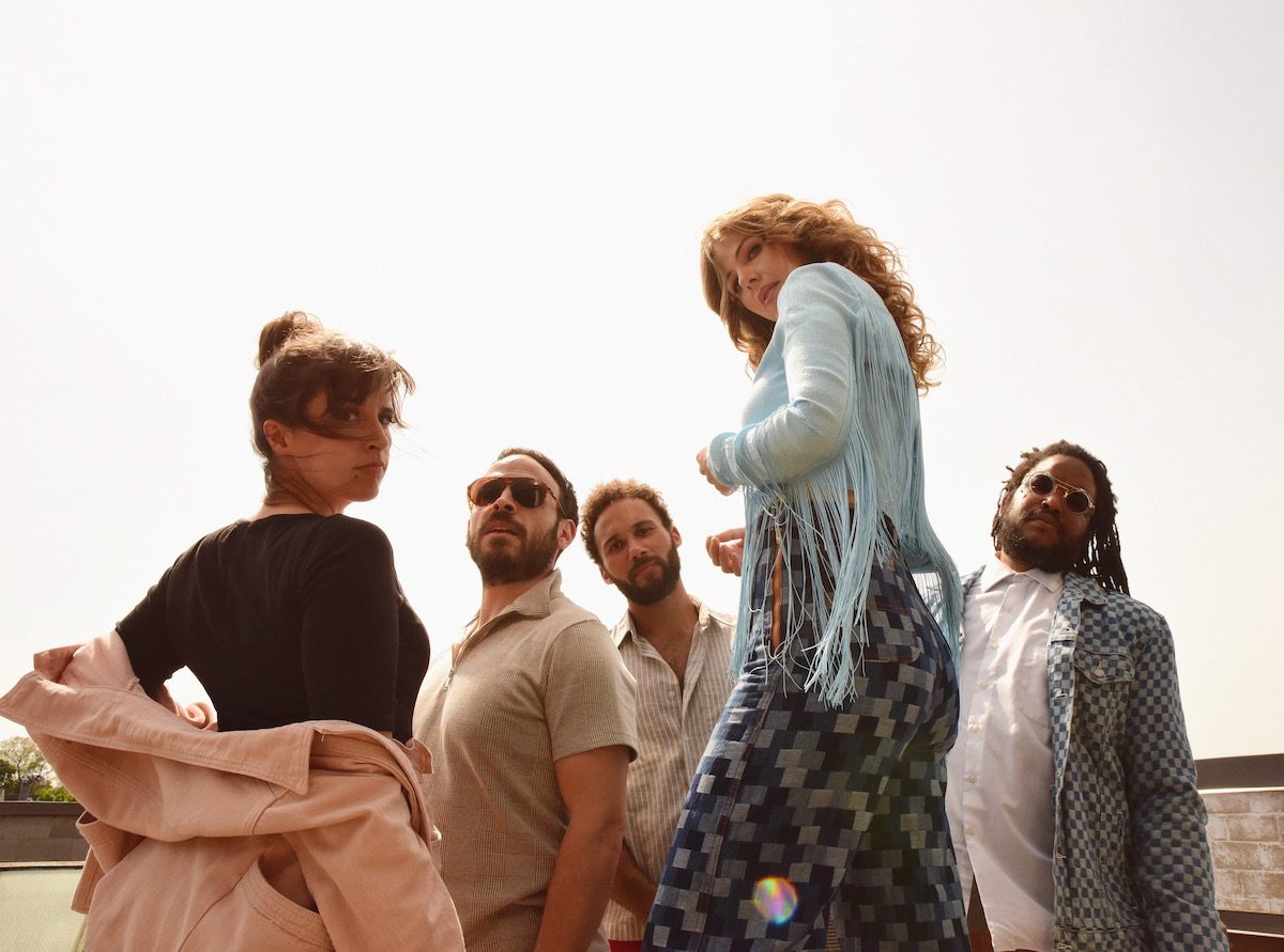 A group photo of the band Lake Street Dive outside in the sunshine