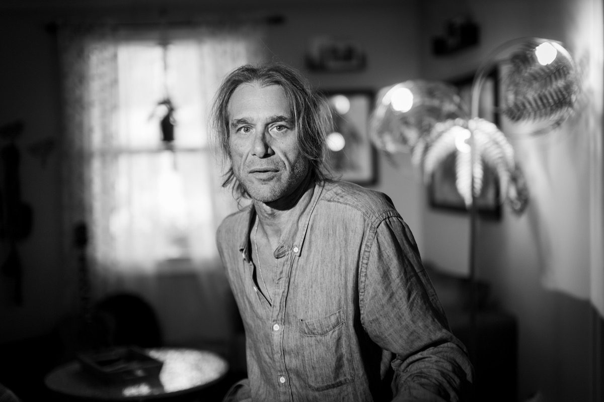 A black and white photo of Todd Snider glancing into the camera