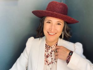 Portrait of Ever More Nest / Kelcy Wilburn in a white jacket and red hat