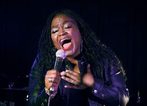 Shemekia Copeland singing passionately into a mic