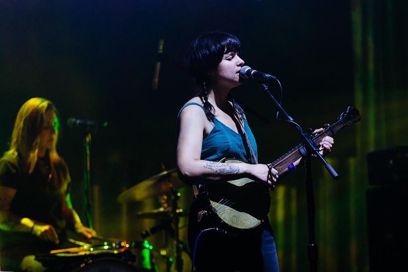 Rachel Baiman plays banjo and sings on a darkened stage