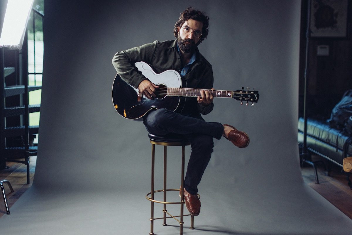 Andrew Duhon with guitar on a photography set