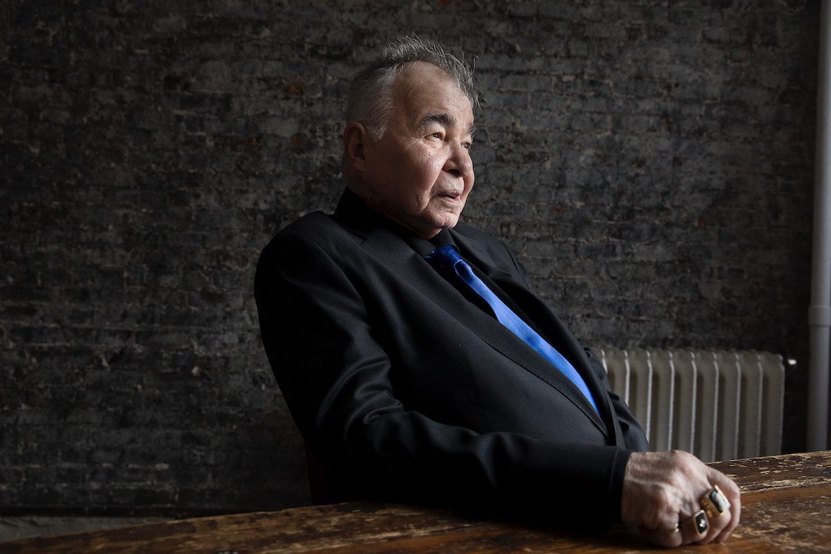 John Prine seated in a chair