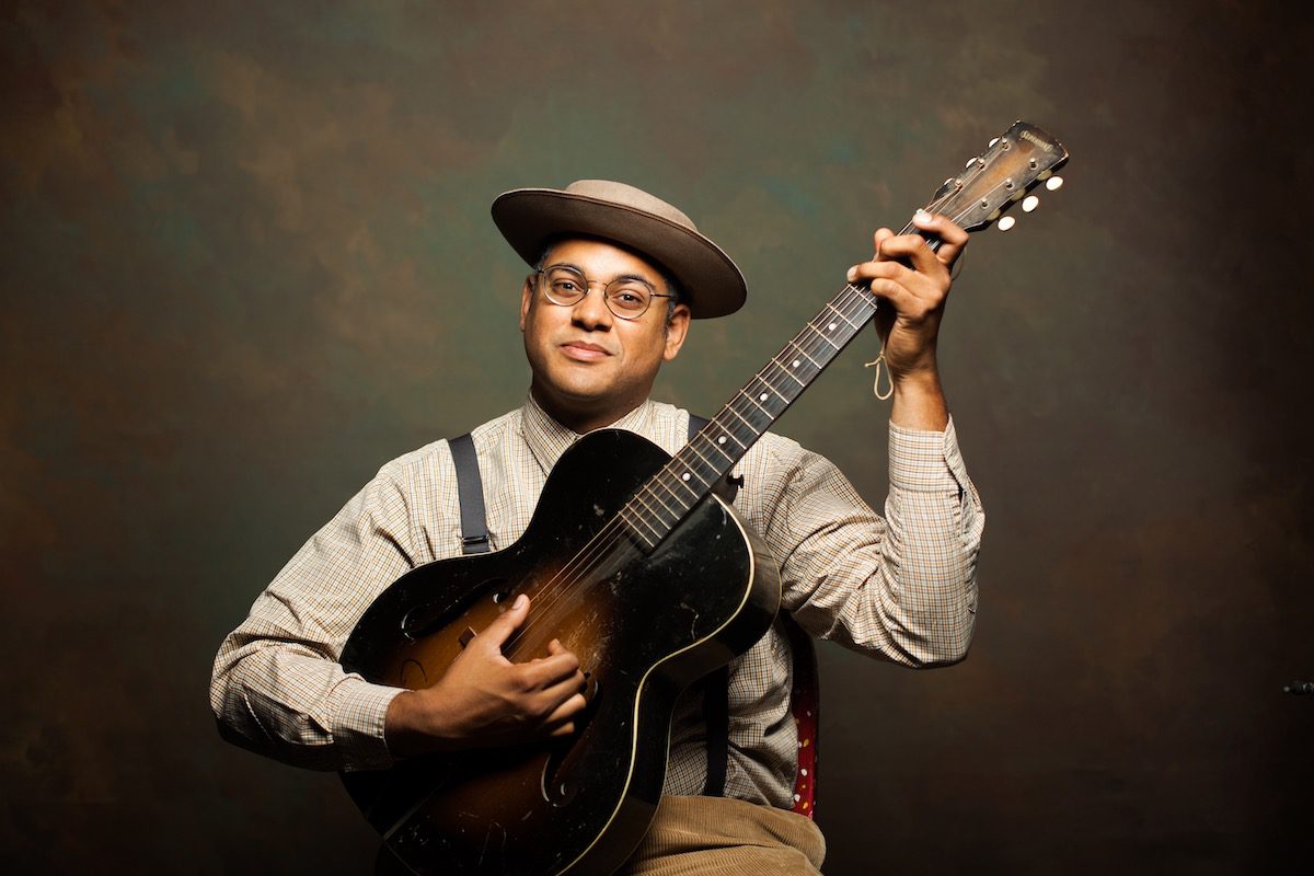 Dom Flemons holding a guitar