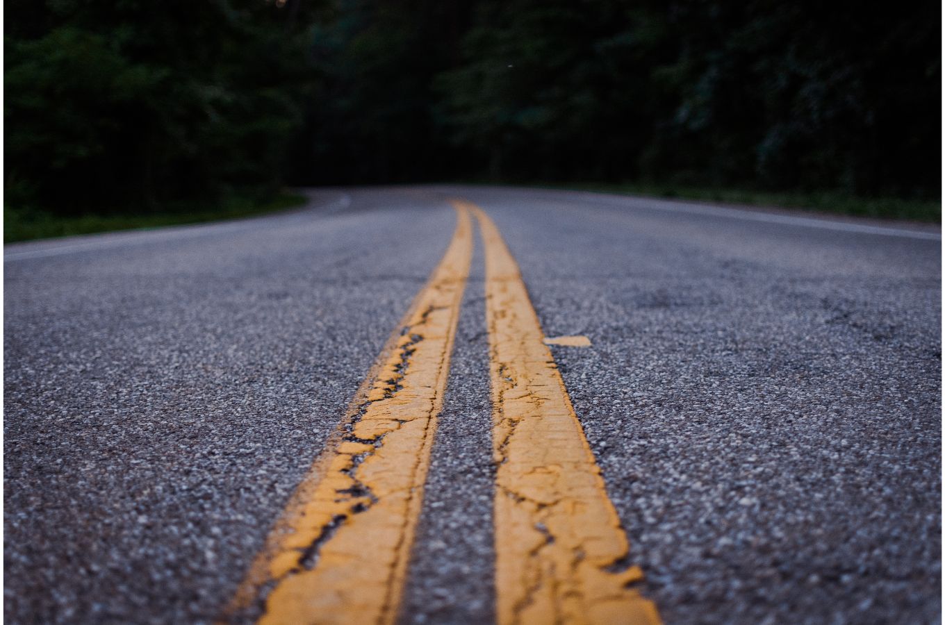 Close up of cracked yellow lines on a dark road