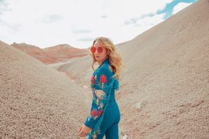 Margo Price in a blue suit amid sand dunes