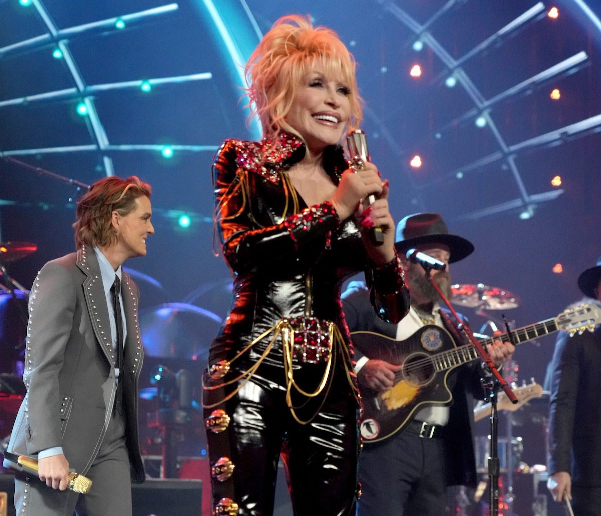 Dolly Parton in black leather onstage; Brandi Carlile in the background