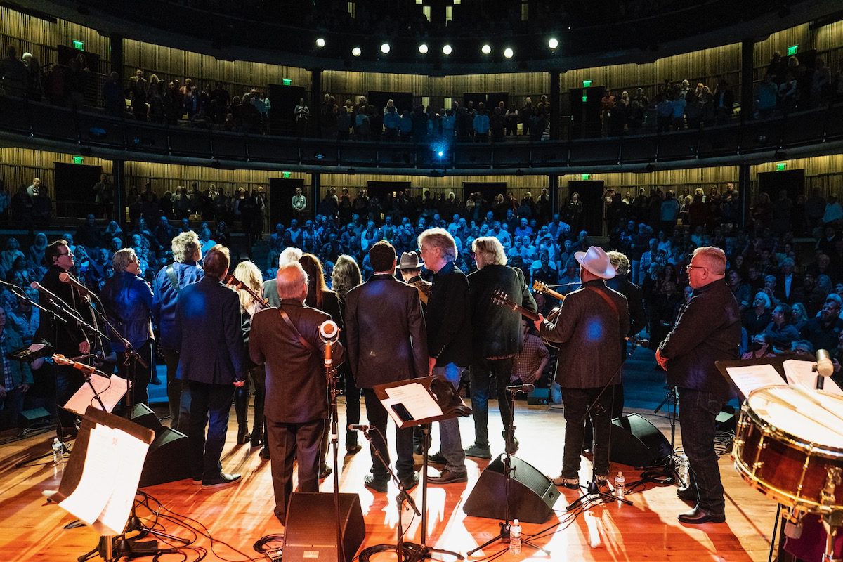 The backs of Nitty Gritty Dirt Band and musical guests onstage