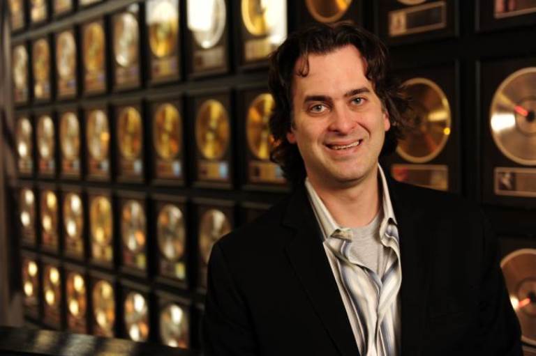 Peter Cooper in front of a wall of gold records