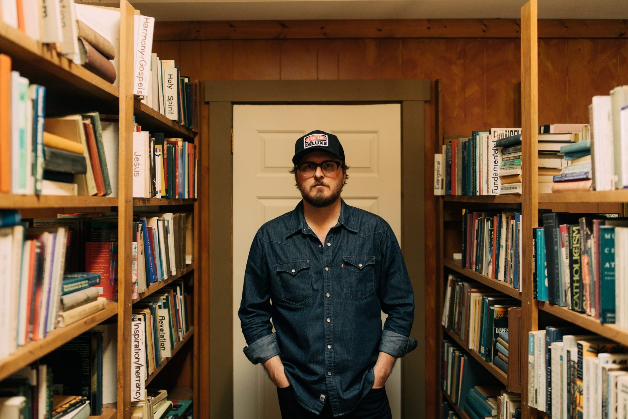 Pony Bradshaw in denim shirt among shelves of used books