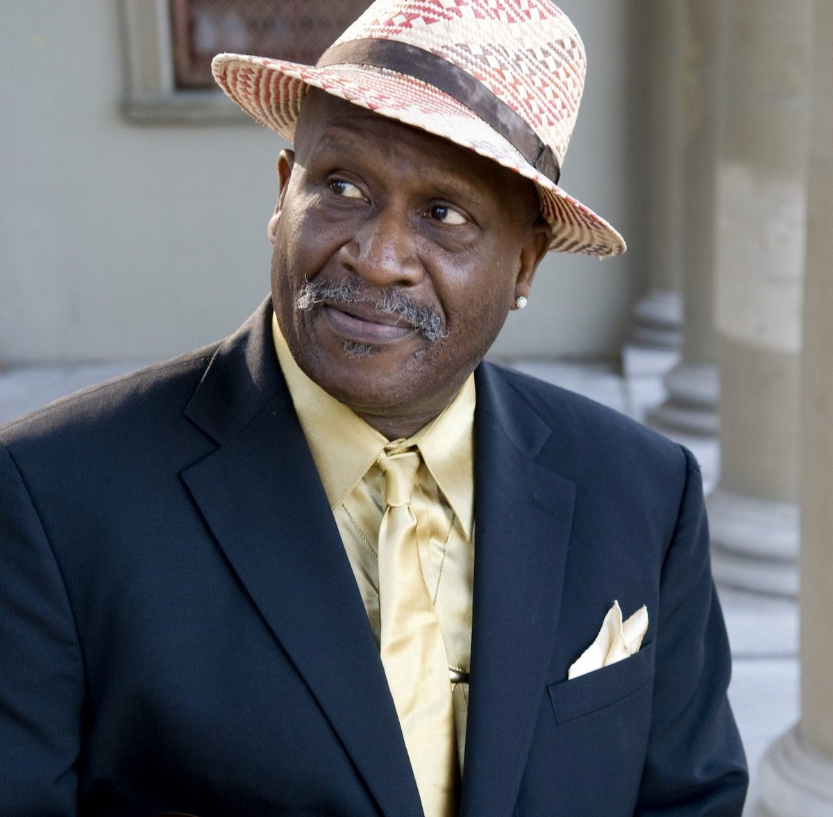 A portrait of Taj Mahal in suit and hat