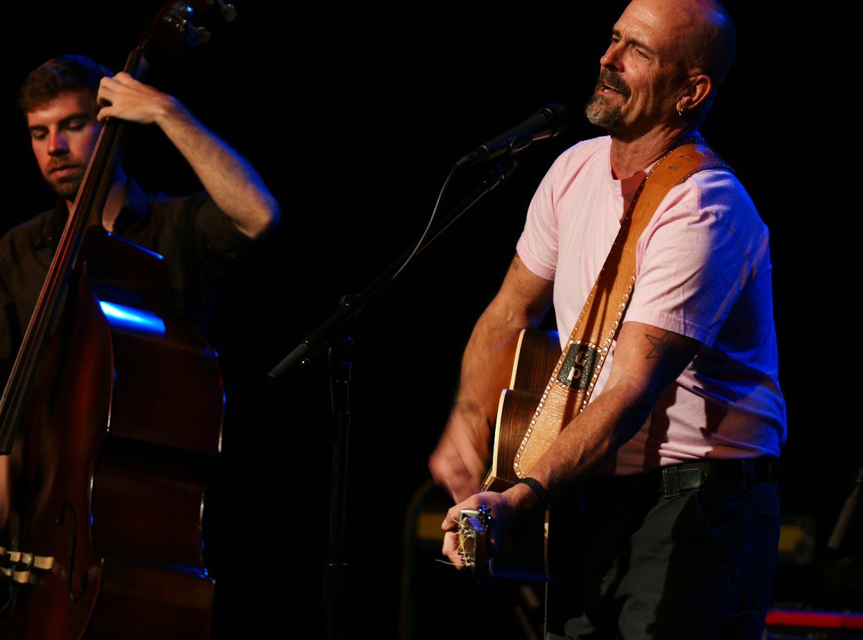 Grant Peeples plays a guitar onstage
