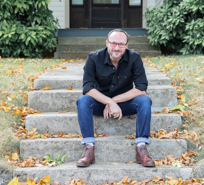 Robby Hecht sitting on stone steps outside