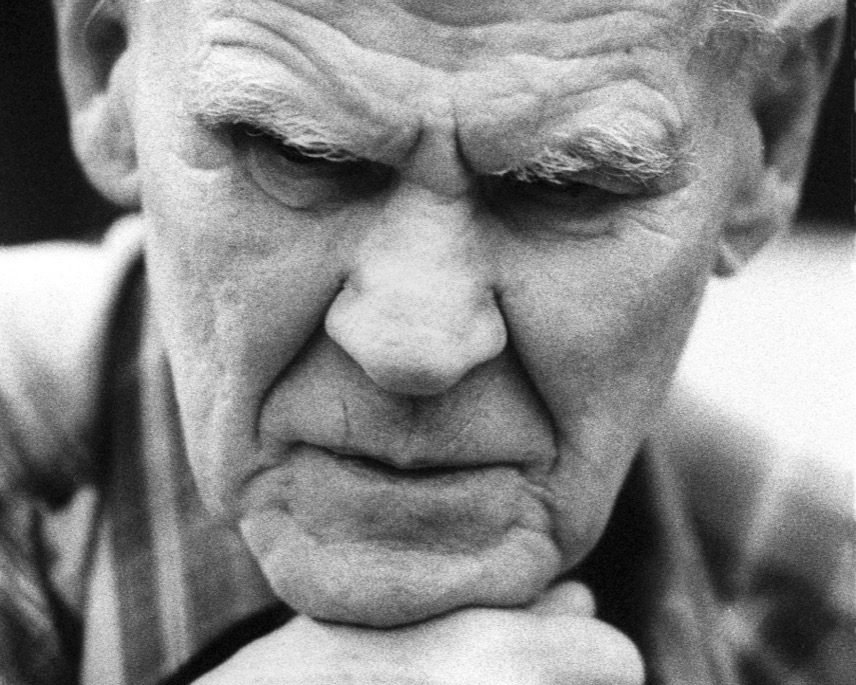 A black and white portrait of Doc Watson