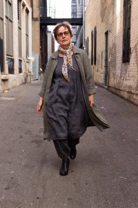 Iris Dement walks between buildings