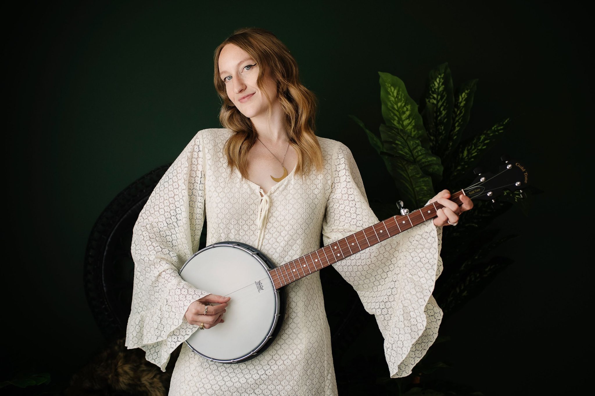 Iris Marlowe in white dress holding a banjo