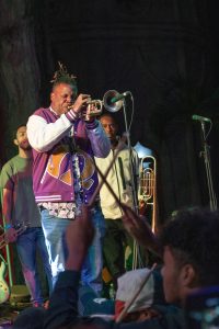 Trumpeter Keyon Harrold solos during Trombone Shorty’s set as a student in the front row clacks his drumsticks along in time.