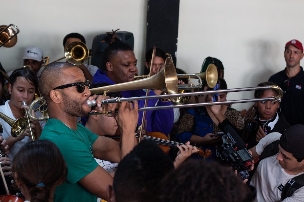 Trombone Shorty performs in a crowded room