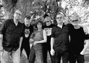 Black and white photo of the six members of Waco Brothers next to a tree