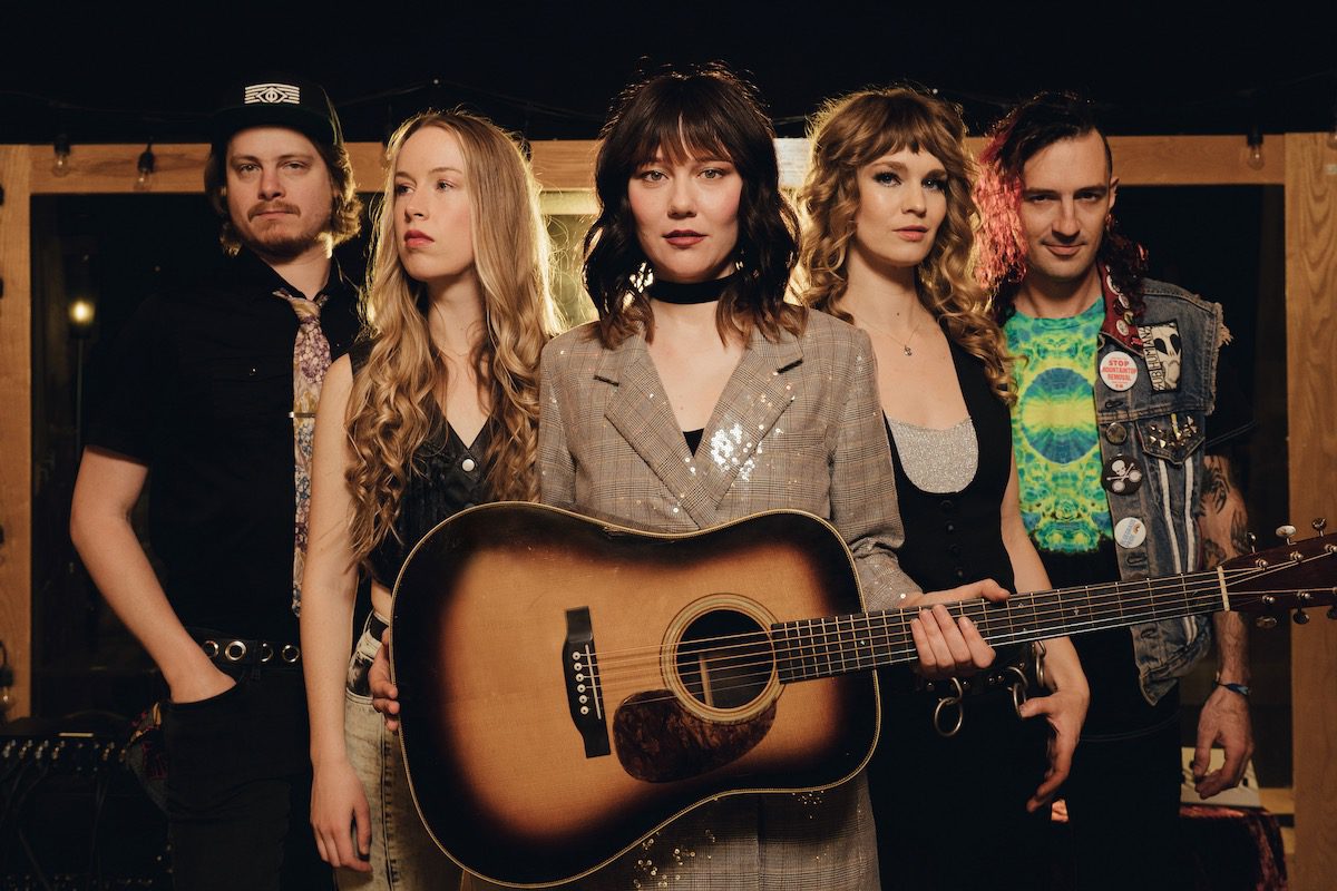 The five members of Molly Tuttle and Golden Highway, with Tuttle at center holding an acoustic guitar