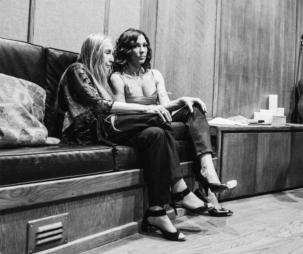 Bobbie Nelson and Amanda Shires sit on a couch together in a black and white photo