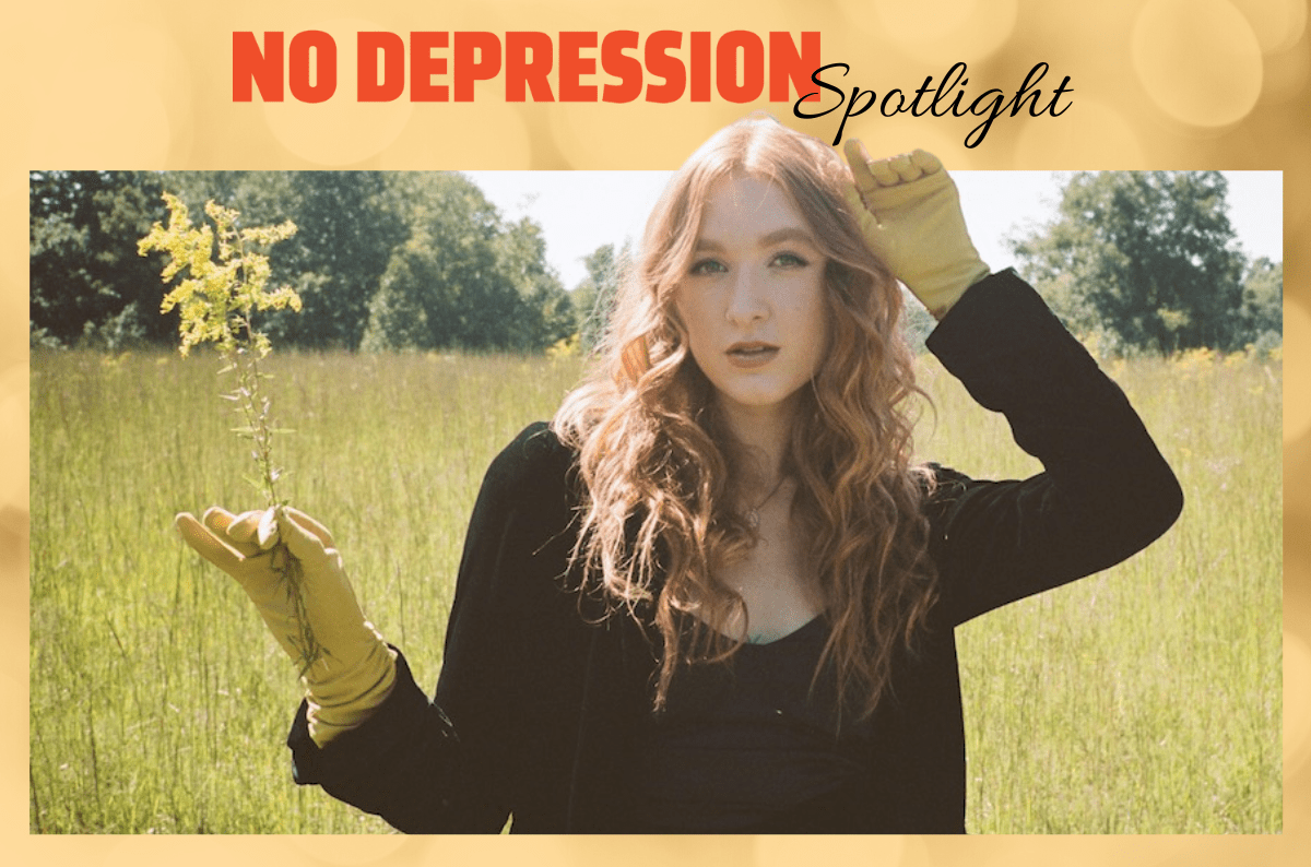 Bella White holds a sprig of yellow flowers in a field of green grass