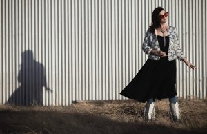 Carter Sampson and her shadow on a corrugated metal wall