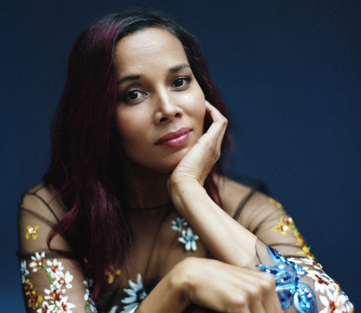 Rhiannon Giddens in embroidered blouse against a rich blue background