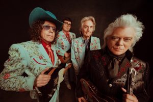 Marty Stuart and the three members of his band in fine embroidered suits