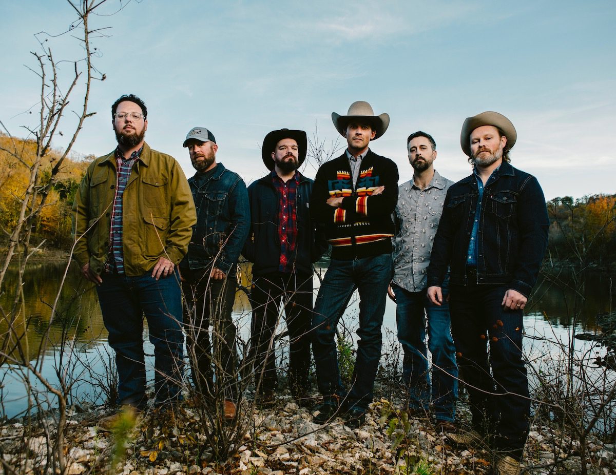 The six members of Turnpike Troubadours standing at the edge of a lake