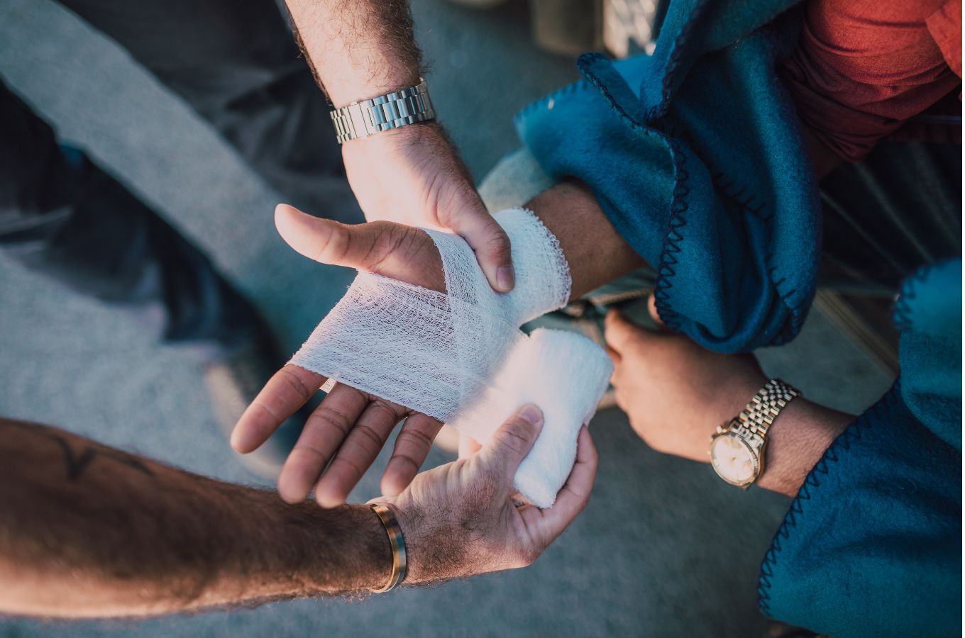Hands shown wrapping a bandage around someone's palm