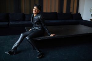 Bettye LaVette in black leather seated on a black table
