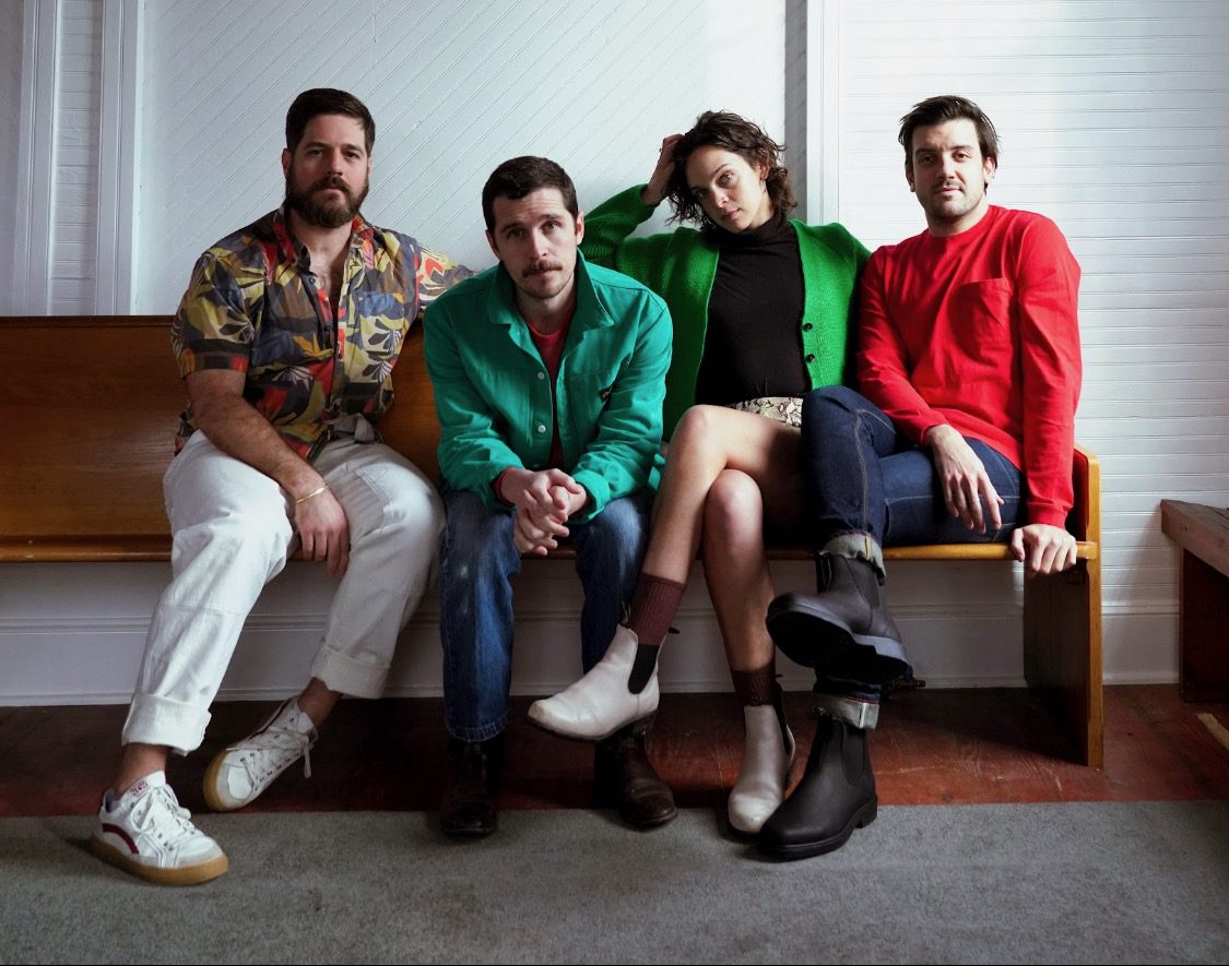 The four members of Mipso seated on a bench