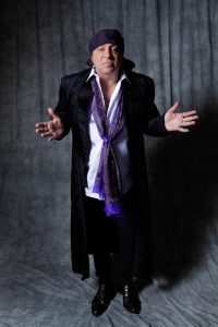 Steven Van Zandt in purple scarf gesturing with his hands apart