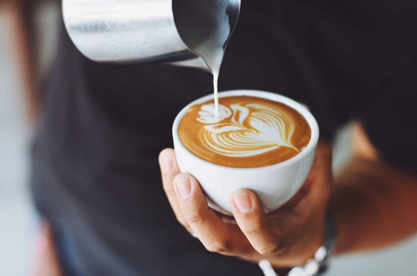 A barista pours a latte