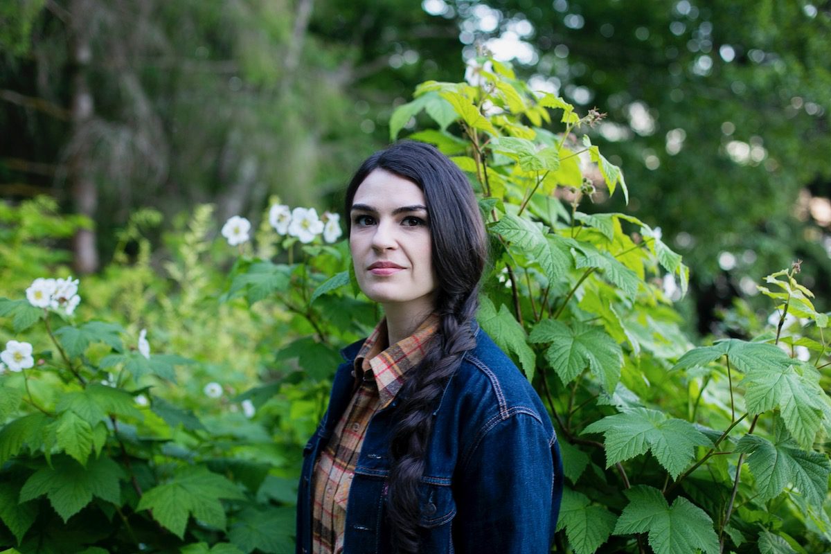 Annie Bartholomew against a green plant