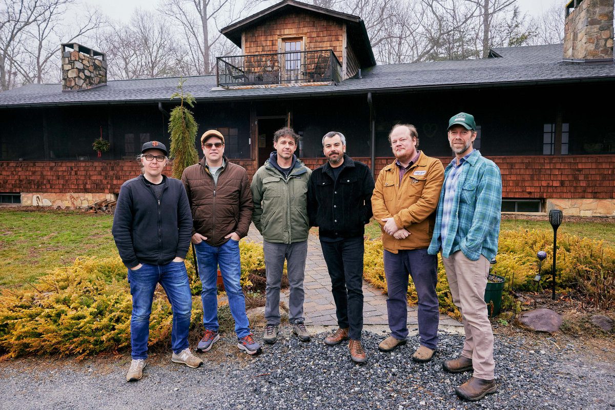 The six members of Steep Canyon Rangers outside a wooden building