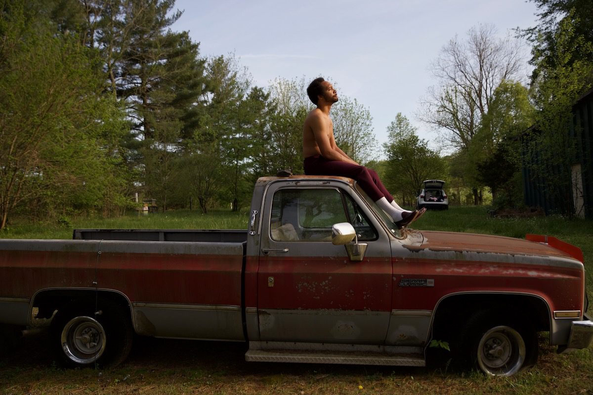 Tré Burt sits on top of the cab of an old truck