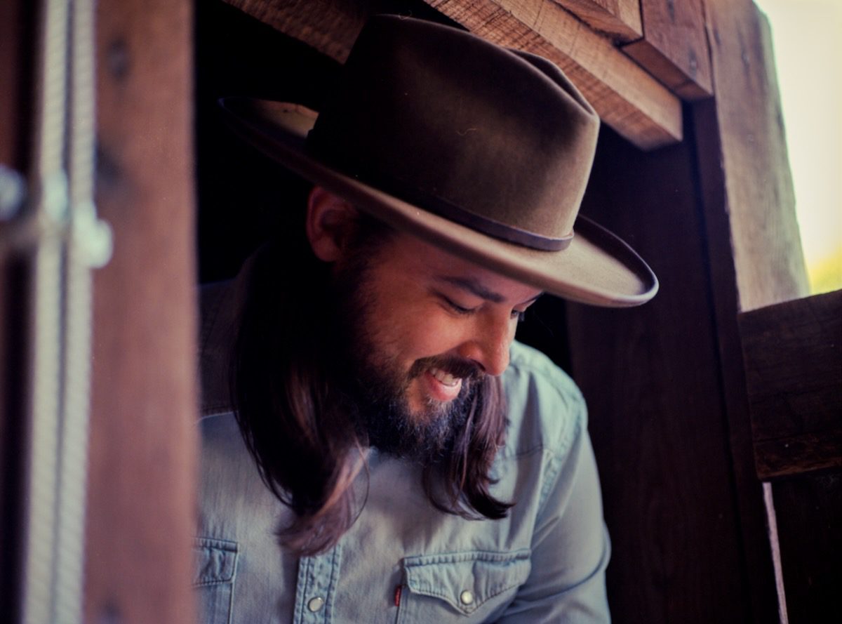 Caleb Caudle framed by a cabin window