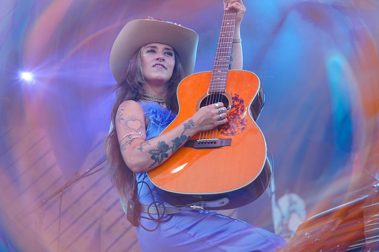 Sierra Ferrell points her guitar skyward onstage