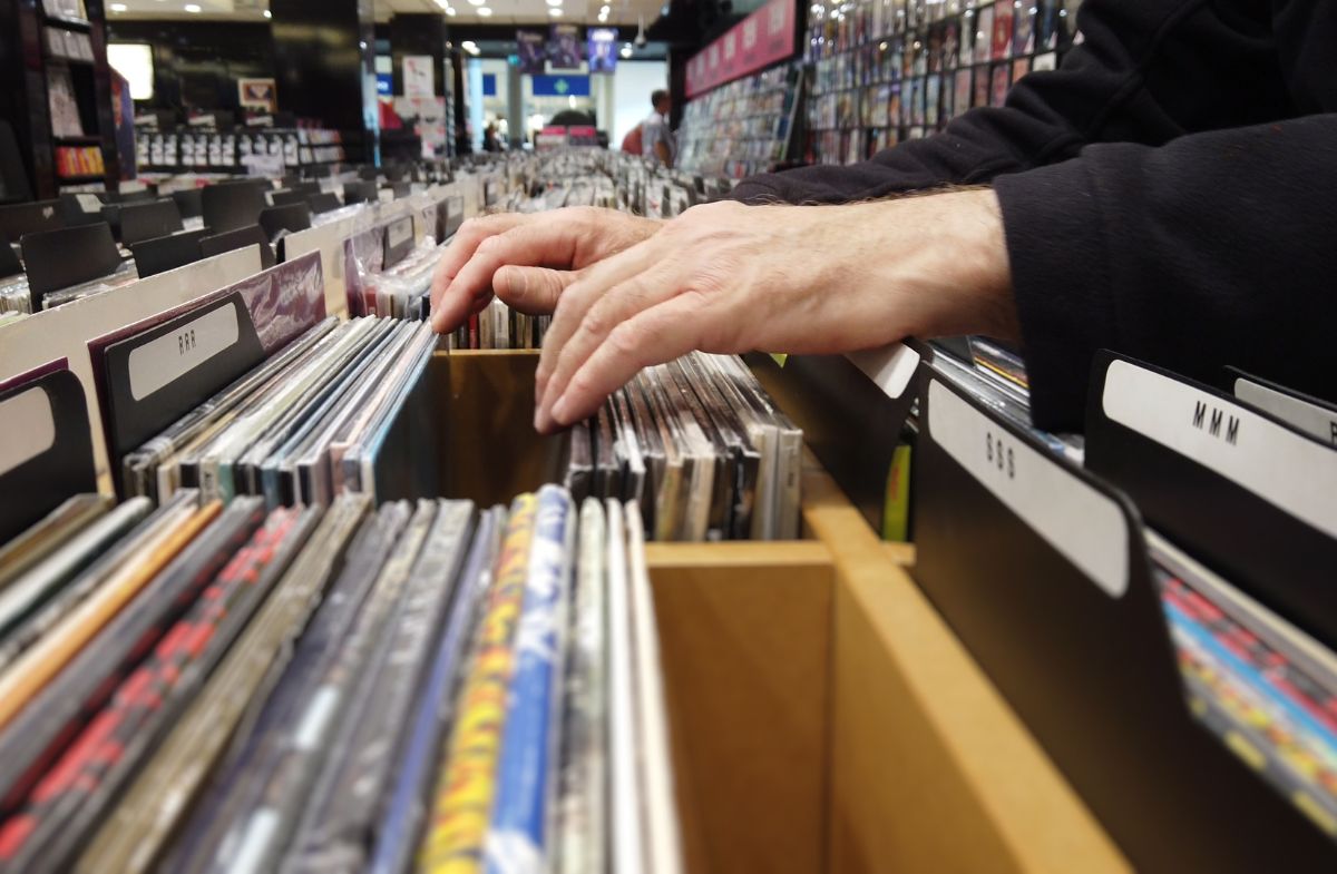 hands flip through records at a record store