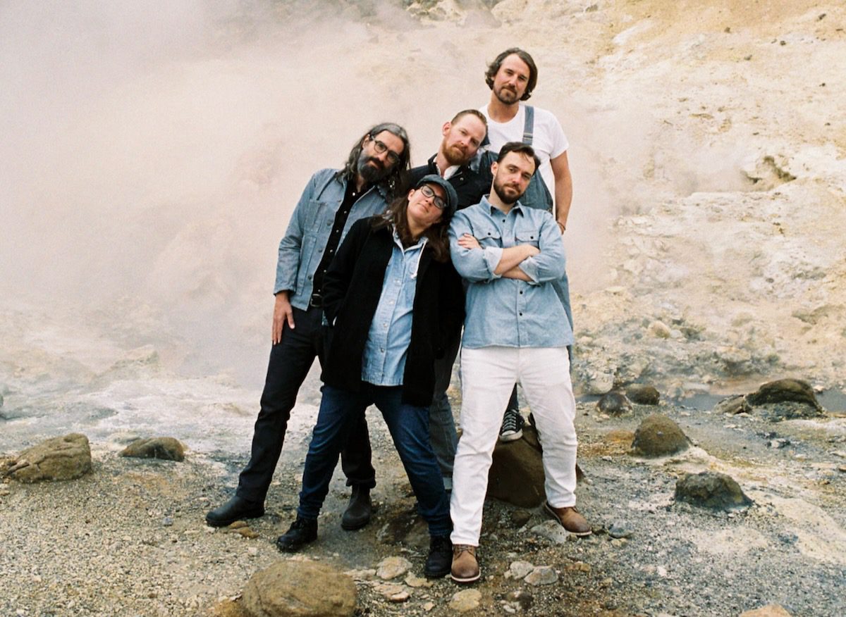 The five members of Fruition standing in a shallow creek