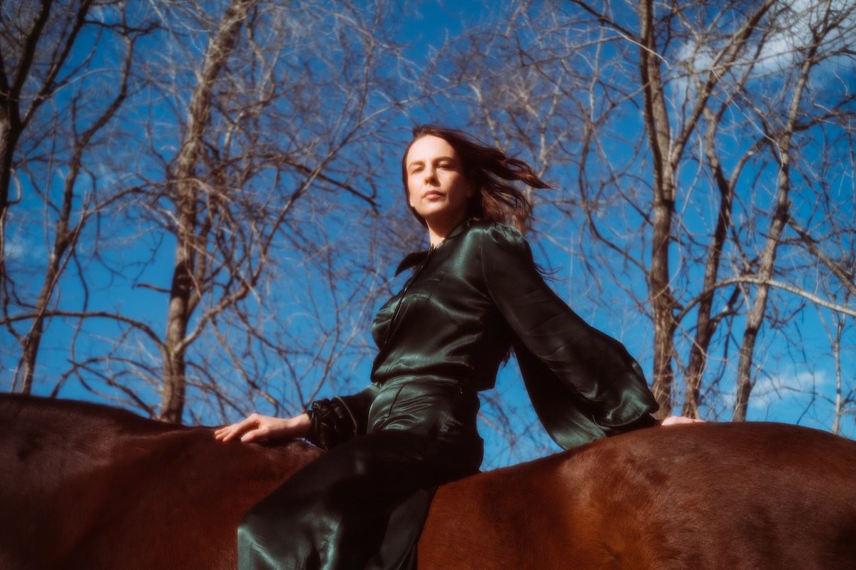 Madi Diaz in side view on horseback