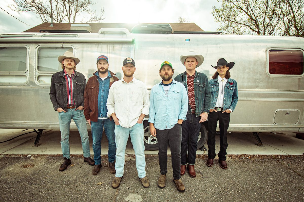 The six members of Clay Street Unit photographed outside a silver Airstream trailer