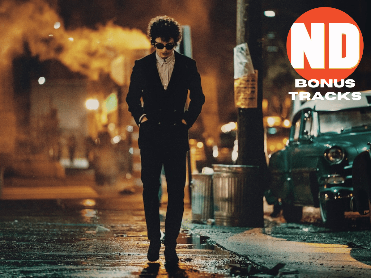 Timothée Chalamet as Bob Dylan walking down a nighttime street.