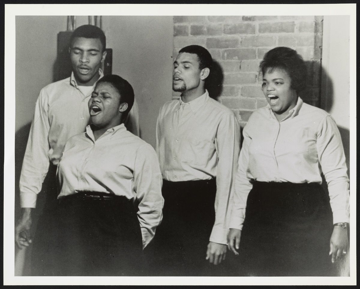 an archive photo of the four members of The Freedom Singers, singing